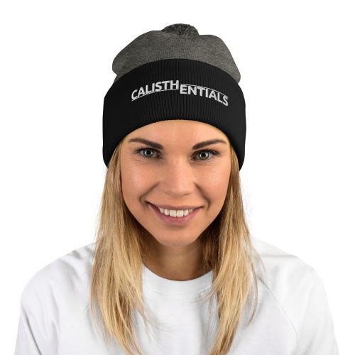 Woman wearing the grey and black Calisthentials Pom-Pom Beanie