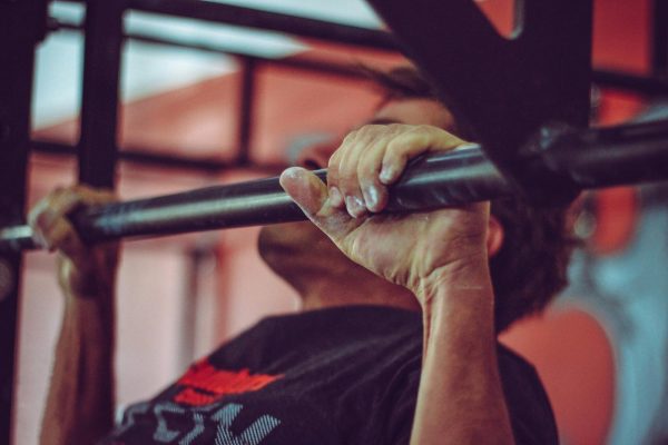 man doing pull ups on a black pull up bar with a shoulder width grip